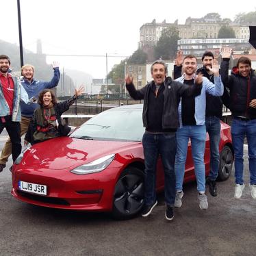 Happy Zapmap team jumping next to an EV