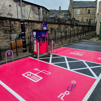 PoGo charge point in car park with pink EV parking bays