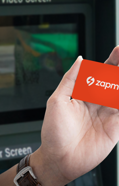 An image of the Zapmap charging card in someone's hand, infront of an EV charger