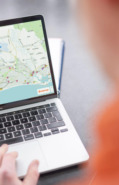 A laptop screen displaying the Zapmap web map, showing available EV chargers