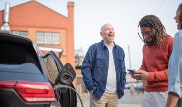 Stock photo - 3 people looking at free charge points on the Zapmap app 